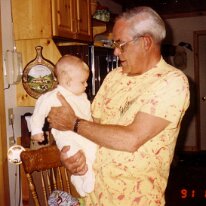 Dad holds baby Scott 1991 cottage