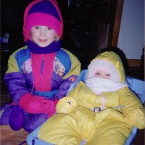 Caitlin with Meaghan yellow snowsuit sled